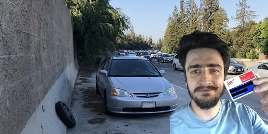Me holding up a roadside-assistance card in front of my silver Honda pulled onto the shoulder of a busy freeway, its blown tire lying on the ground behind the car.