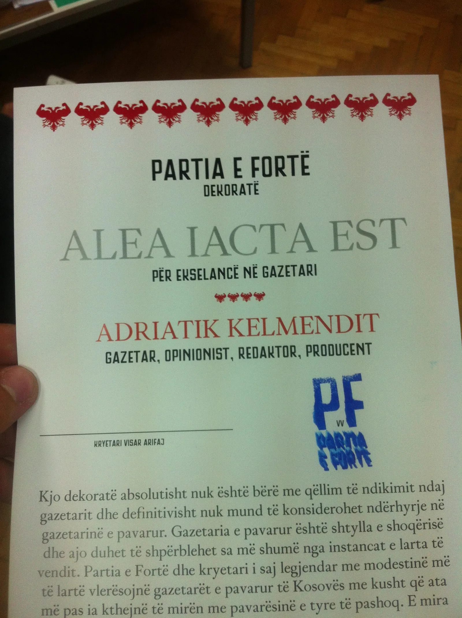 A printed Partia e Fortë award certificate, the "Alea Iacta Est" decoration for excellence in journalism, issued to the journalist Adriatik Kelmendi and edged with a row of small red flexing-arm eagles.