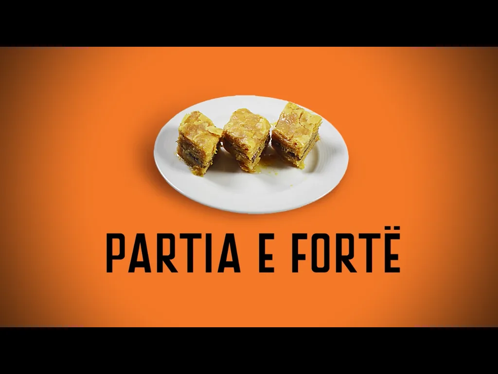 A Partia e Fortë spot: three pieces of baklava on a white plate against the party's orange, with "PARTIA E FORTË" beneath.