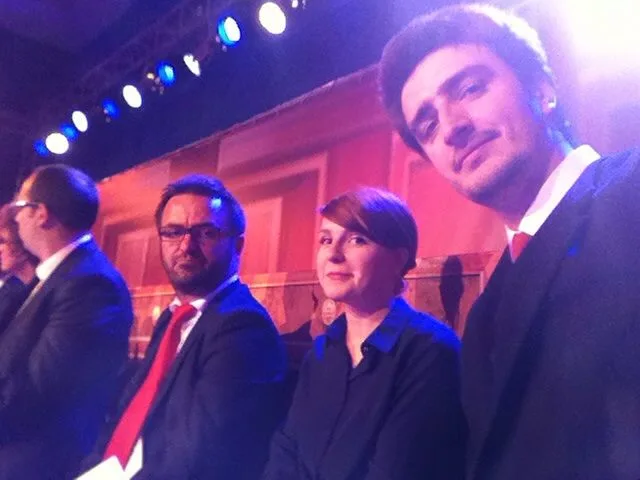 Me on the right of frame at a televised election debate, in a suit and tie under the studio lights, with the other candidates on the panel beside me.